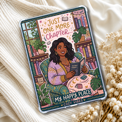 A clear phone case with a colorful illustrated design of a woman sitting in a cozy armchair and reading a book, surrounded by plants and bookshelves. The text on the case reads 'Just One More Chapter' and 'My Happy Place Cozy Vibes'.