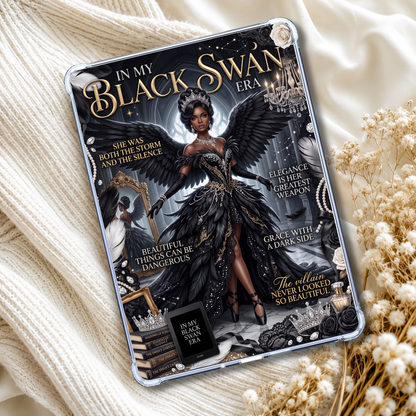 A tablet case with a gothic 'In My Black Swan Era' graphic design, styled on a cream-colored knit blanket with dried flowers.